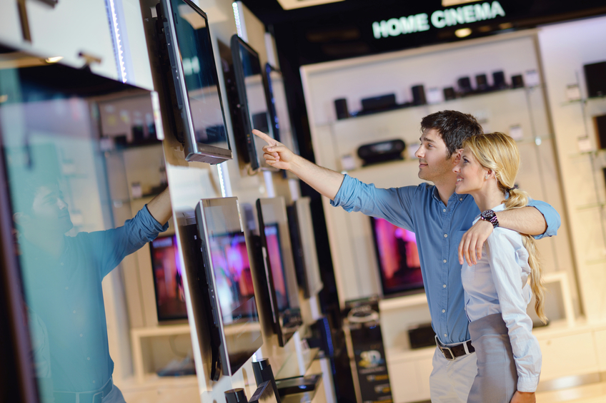 Young couple in an electronics store pointing at a TV