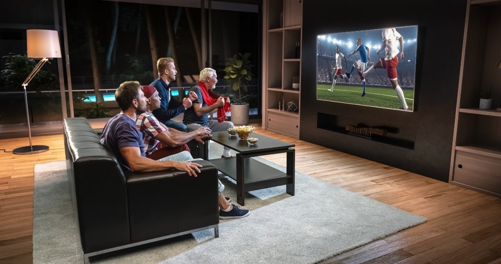 mates watching football at home on a flatscreen TV recessed into the wall