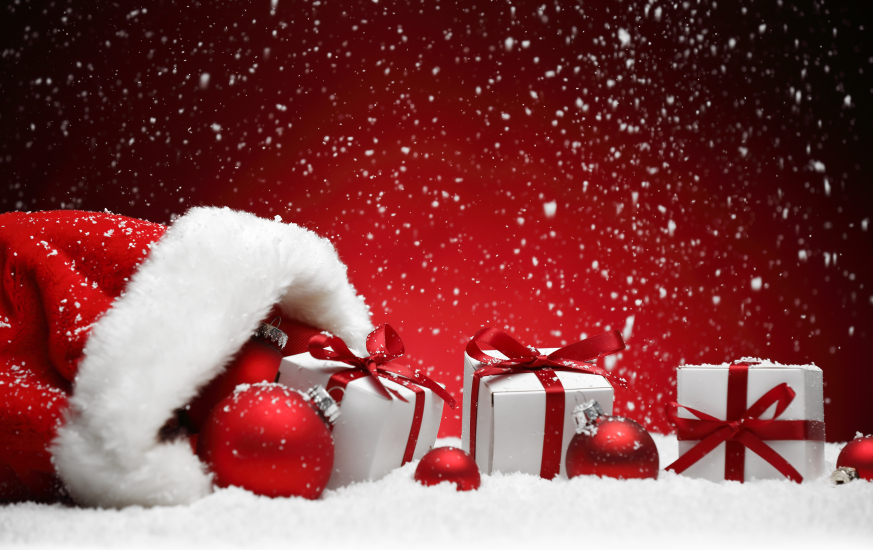 Santa Claus red bag with Christmas balls and gift box on snow.