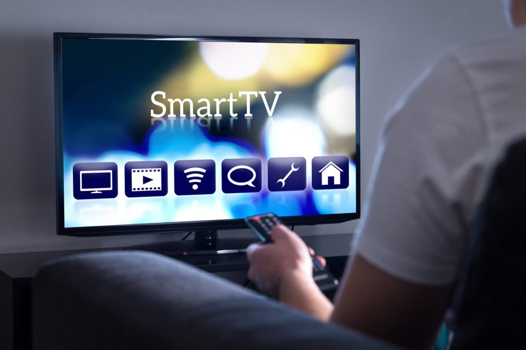 Man watching smart tv. Choosing movie or series from the menu. Person holding remote control. User interface on television screen.