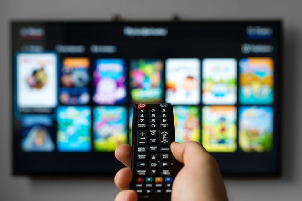 Someone pointing a TV remote at a smart TV