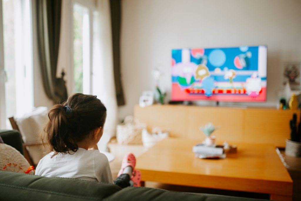 Young girl watching a kids program on a smart tv