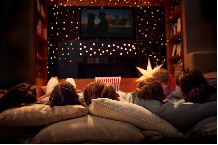 A group of people lying on pillows watching a movie