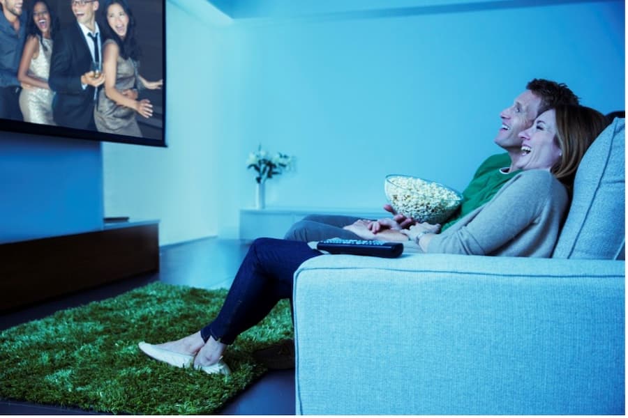 A person sitting on a couch watching a television